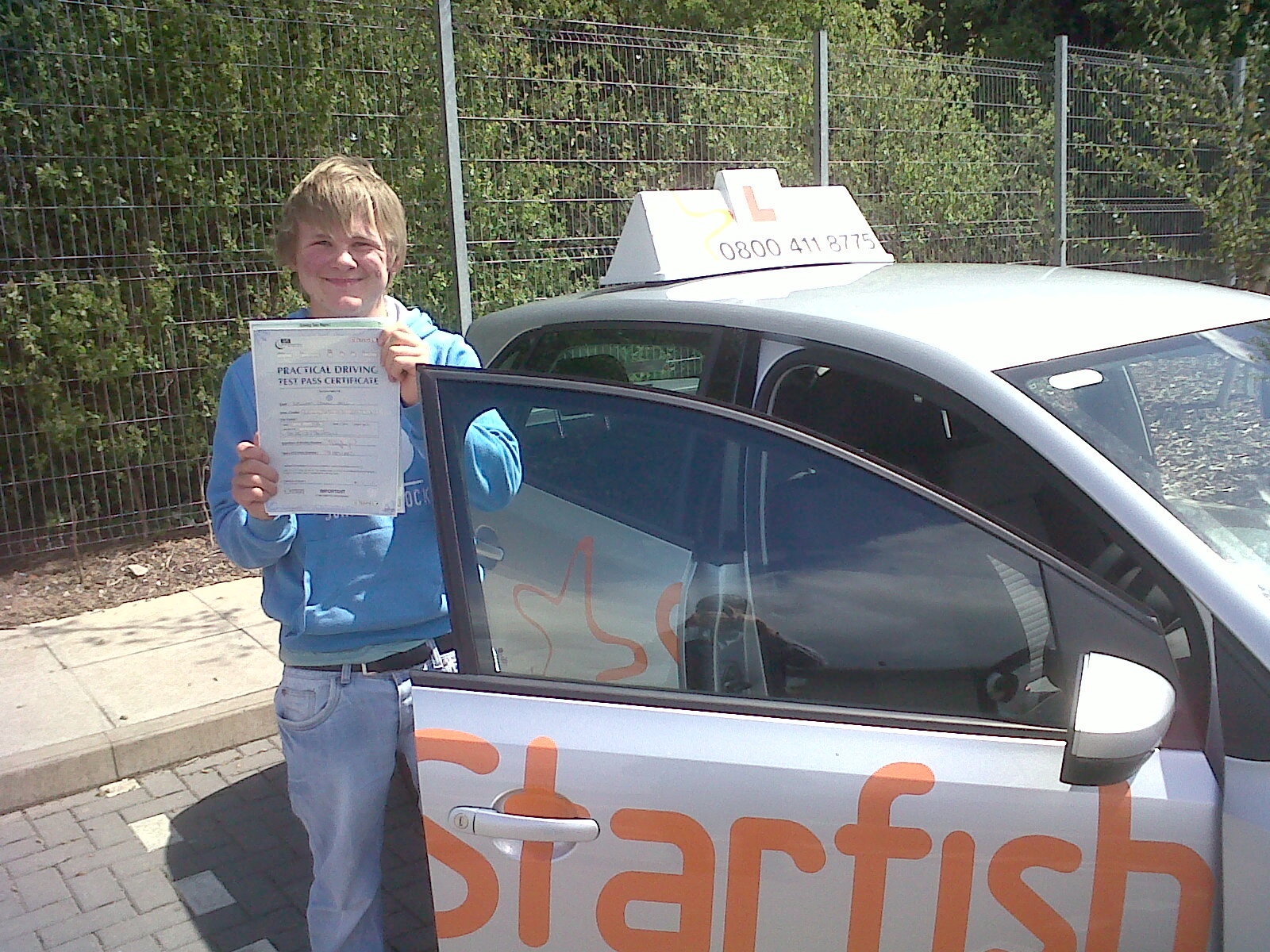 Will Bell with his Practical Driving Test Pass Certificate outside Taunton Driving Test Centre