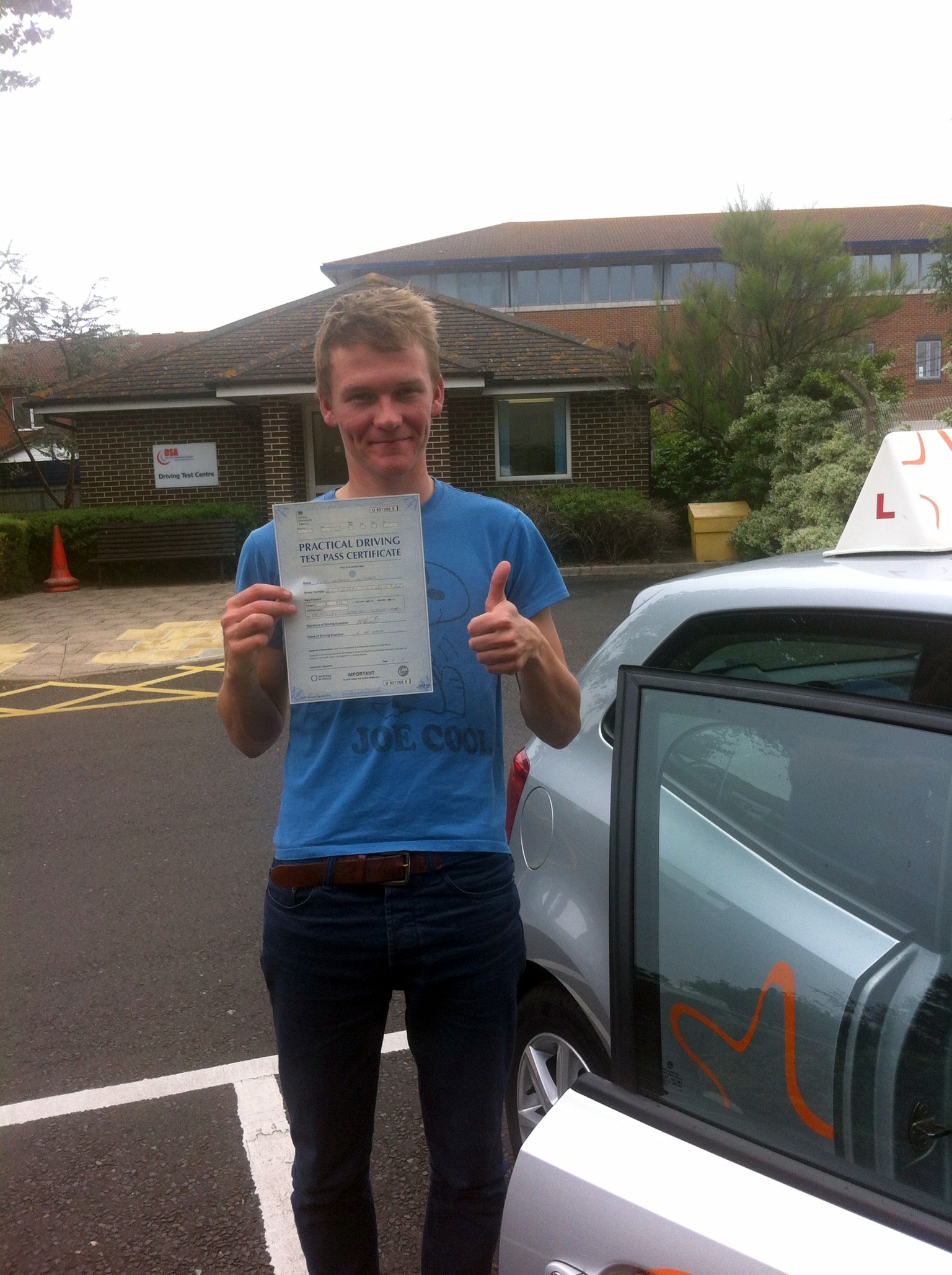 Joel with his Practical Driving Test Pass Certificate outside Weston-super-Mare Driving Test Centre