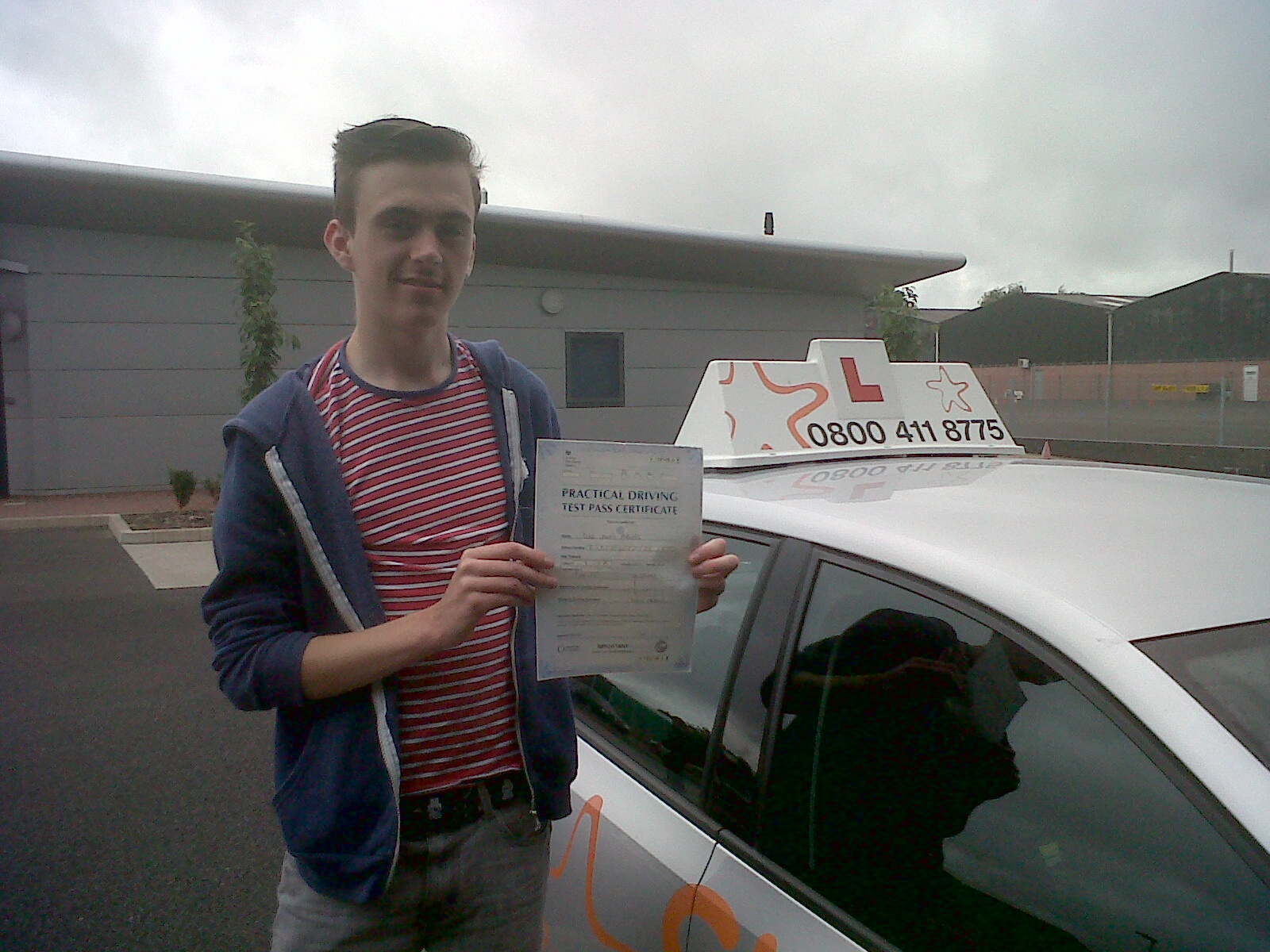 Luke with his Practical Driving Test Pass Certificate outside the Driving Test Centre in Taunton