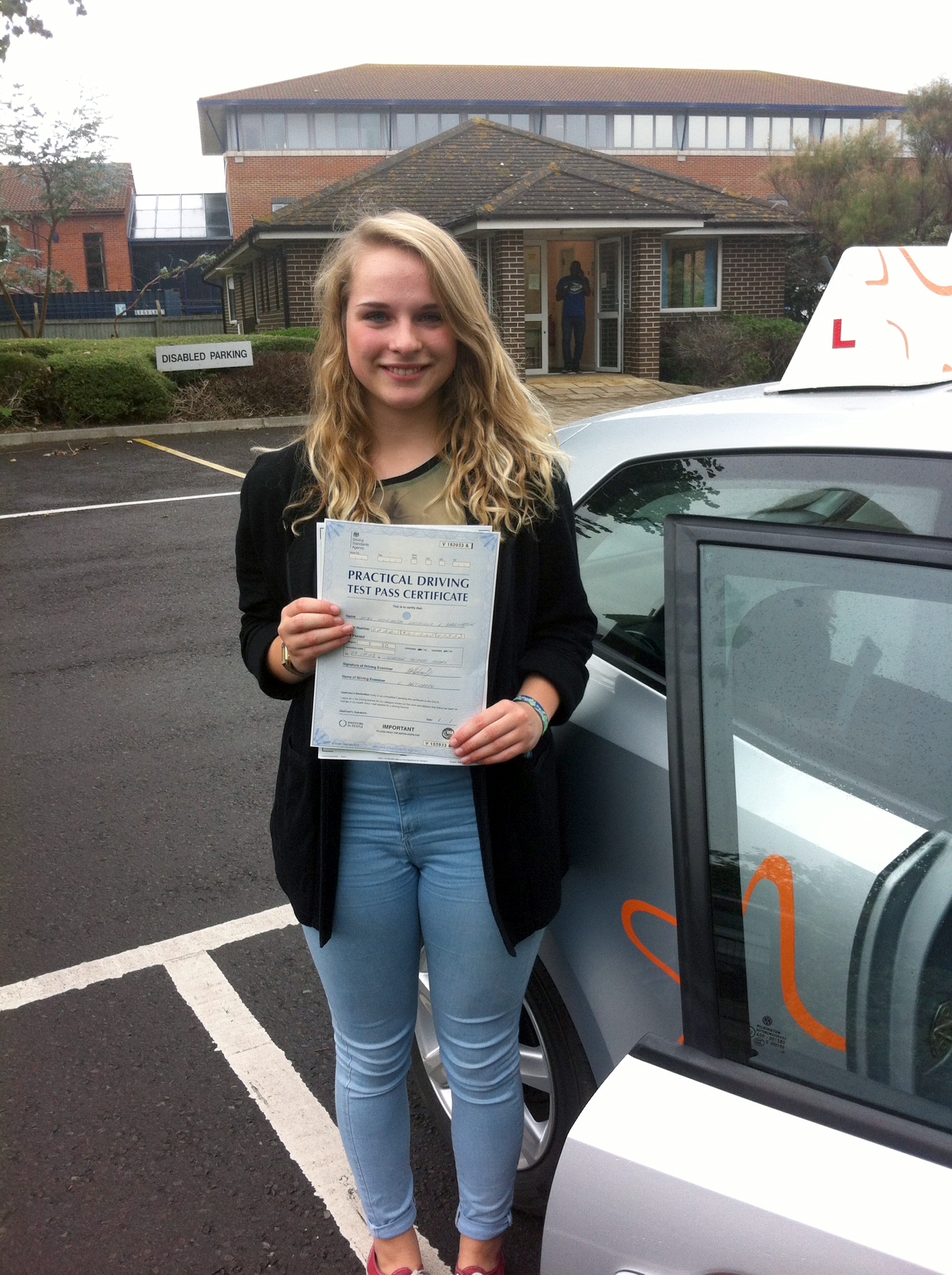 Holly with her Practical Driving Test Pass Certificate outside Weston-Super-Mare Driving Test Centre.