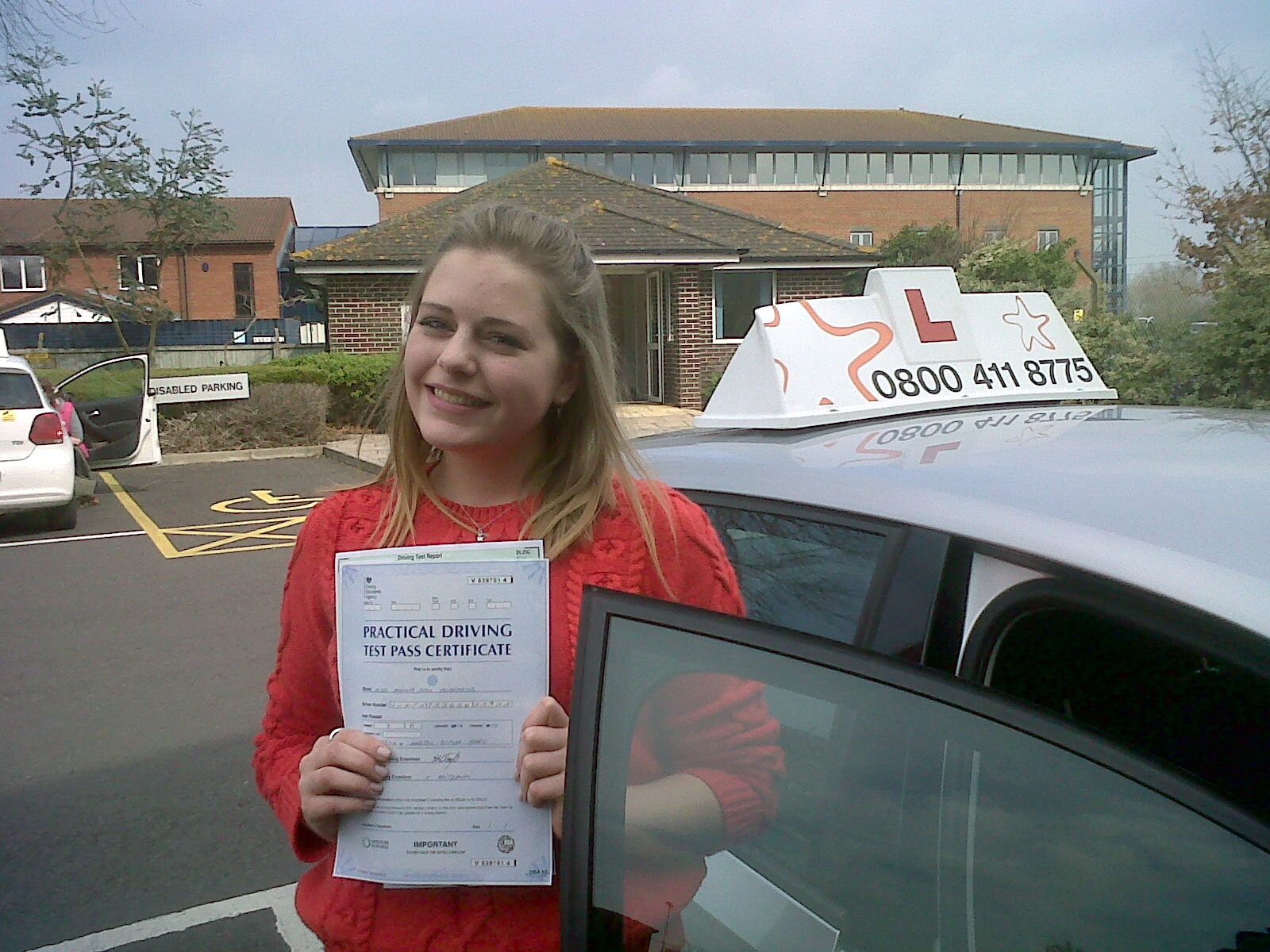Millie with her Practical Driving Test Pass Certificate outside Weston-super-Mare Driving Test Centre