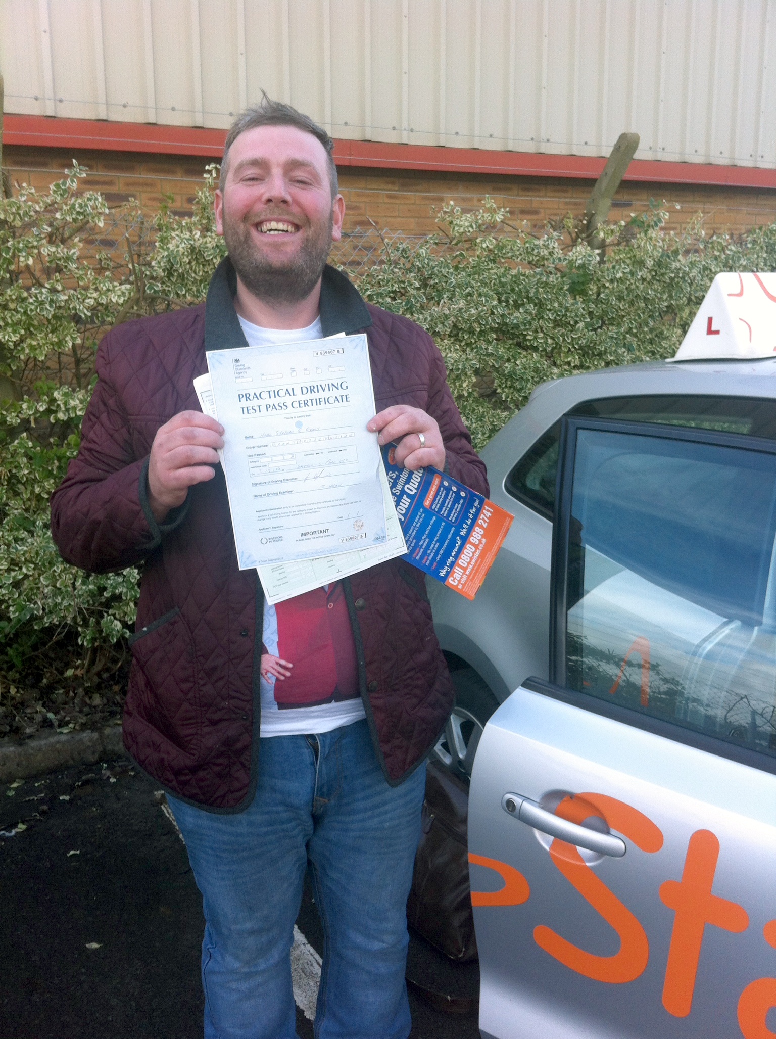 Noel with his Practical Driving Test Pass Certificate outside Weston-super-Mare Driving Test Centre