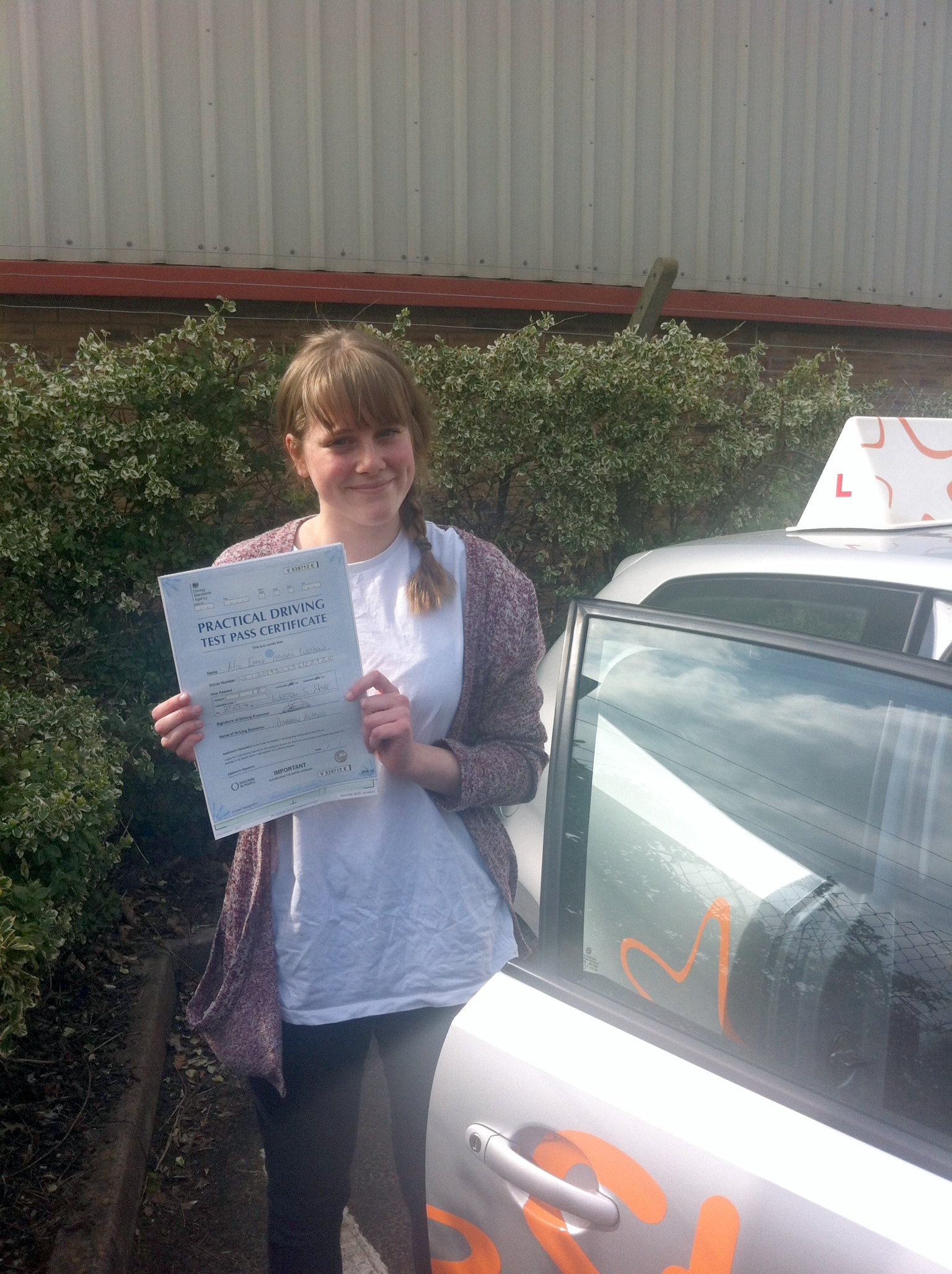 Emily with her Practical Driving Test Pass Certificate outside Weston-super-Mare Driving Test Centre.