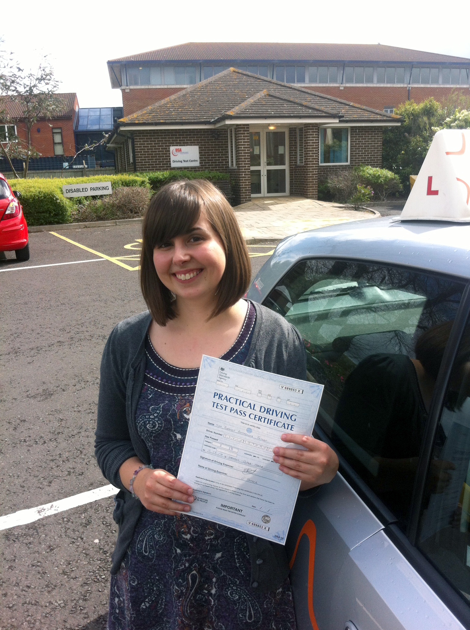 Eleanor with her Practical Driving Test Pass Certificate outside Weston-super-Mare Driving Test Centre.