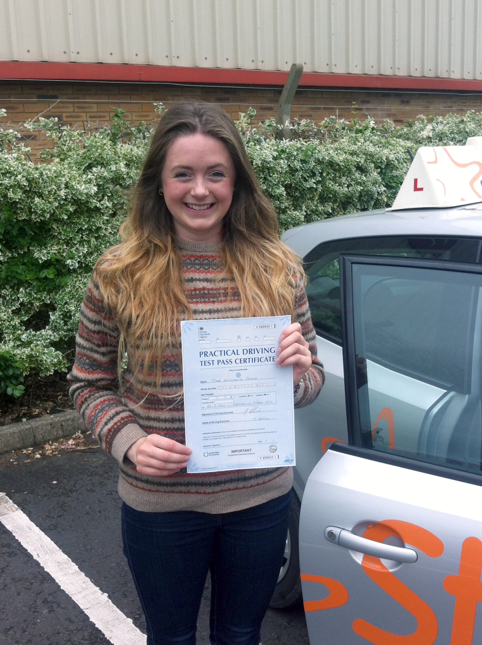 Jade with her Practical Driving Test Pass Certificate outside Weston-super-Mare Driving Test Centre