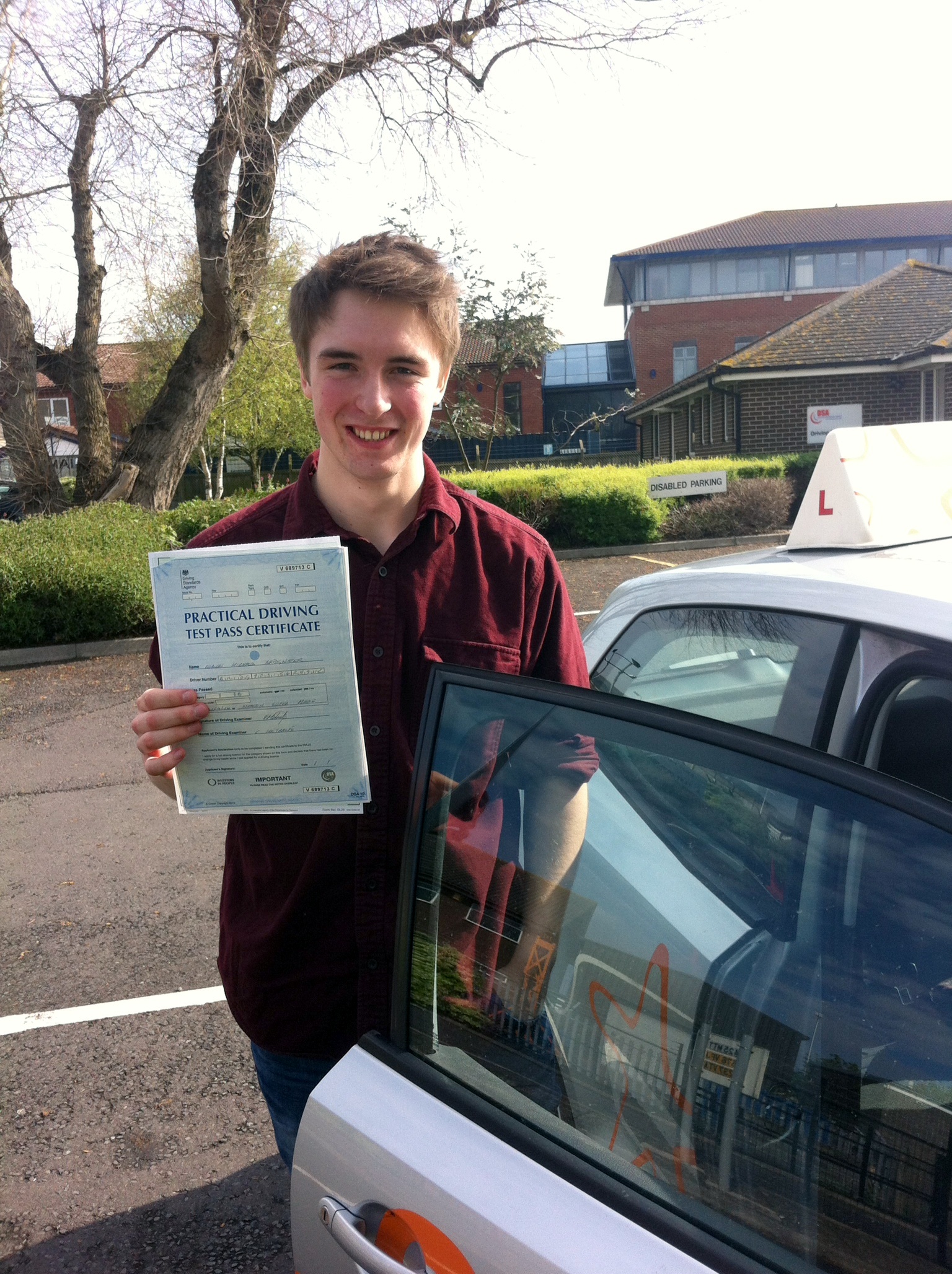 Robbie with his Practical Driving Test Pass Certificate outside Weston-super-Mare Driving Test Centre