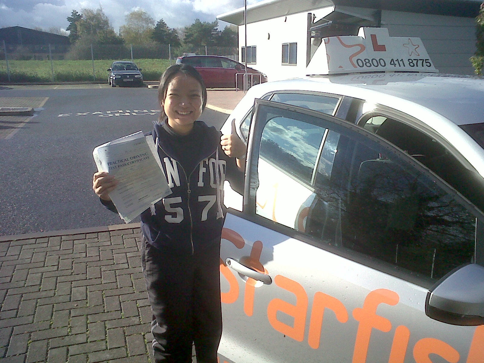 Cynthia with her Practical Driving Test Pass Certificate outside Taunton Driving Test Centre.