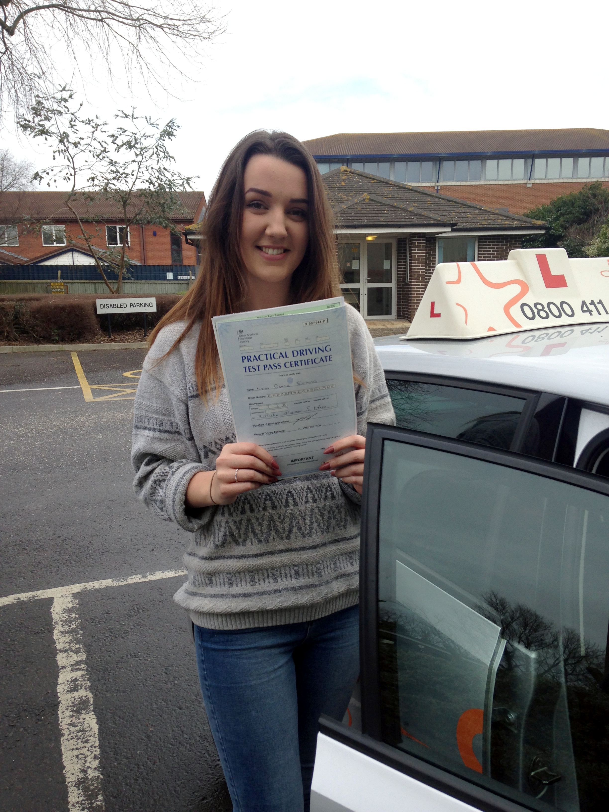 Grace with her Practical Driving Test Pass Certificate outside Weston-super-Mare Driving Test Centre.