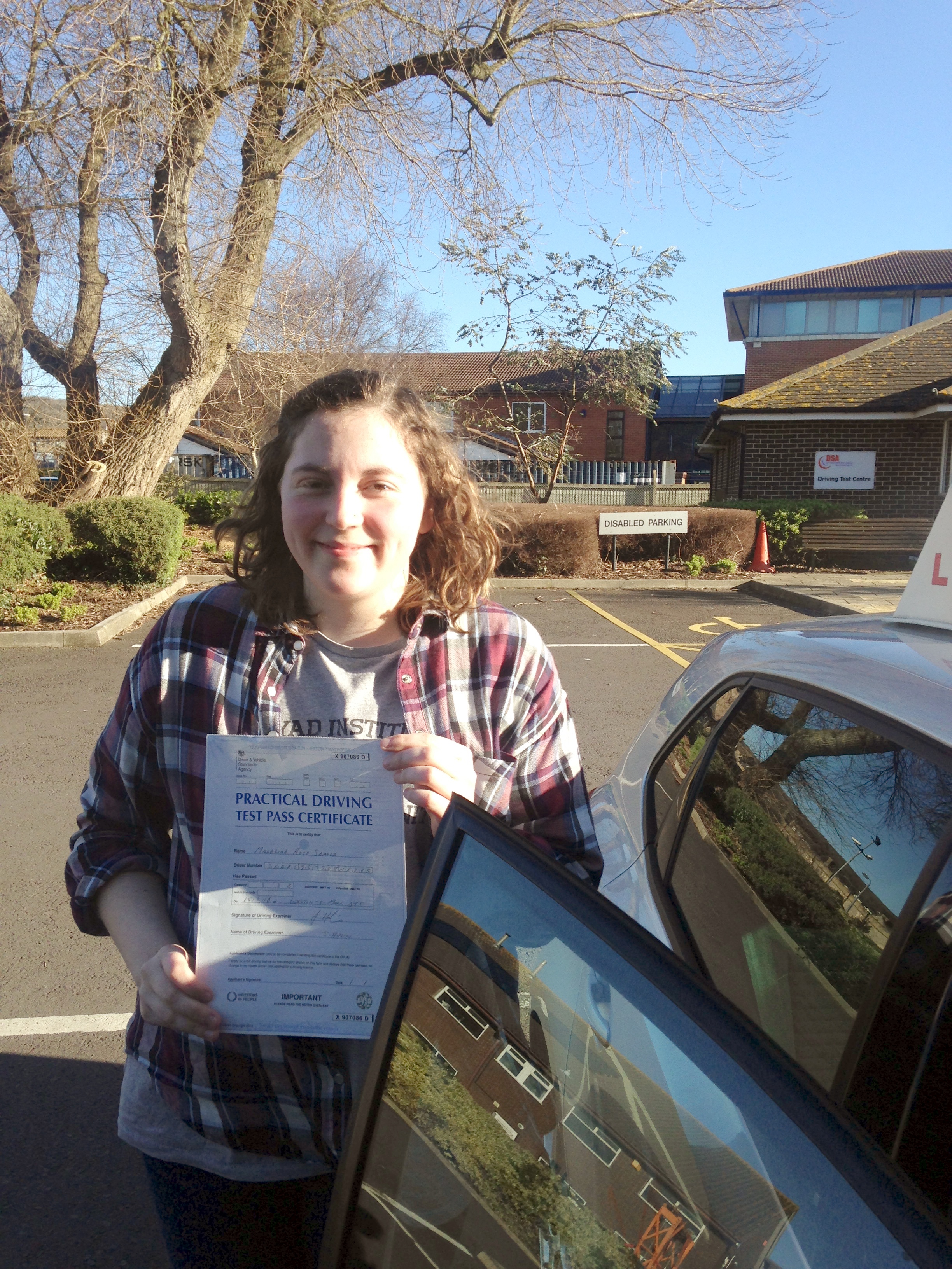 Maddie with her Practical Driving Test Pass Certificate outside Weston-super-Mare Driving Test Centre.