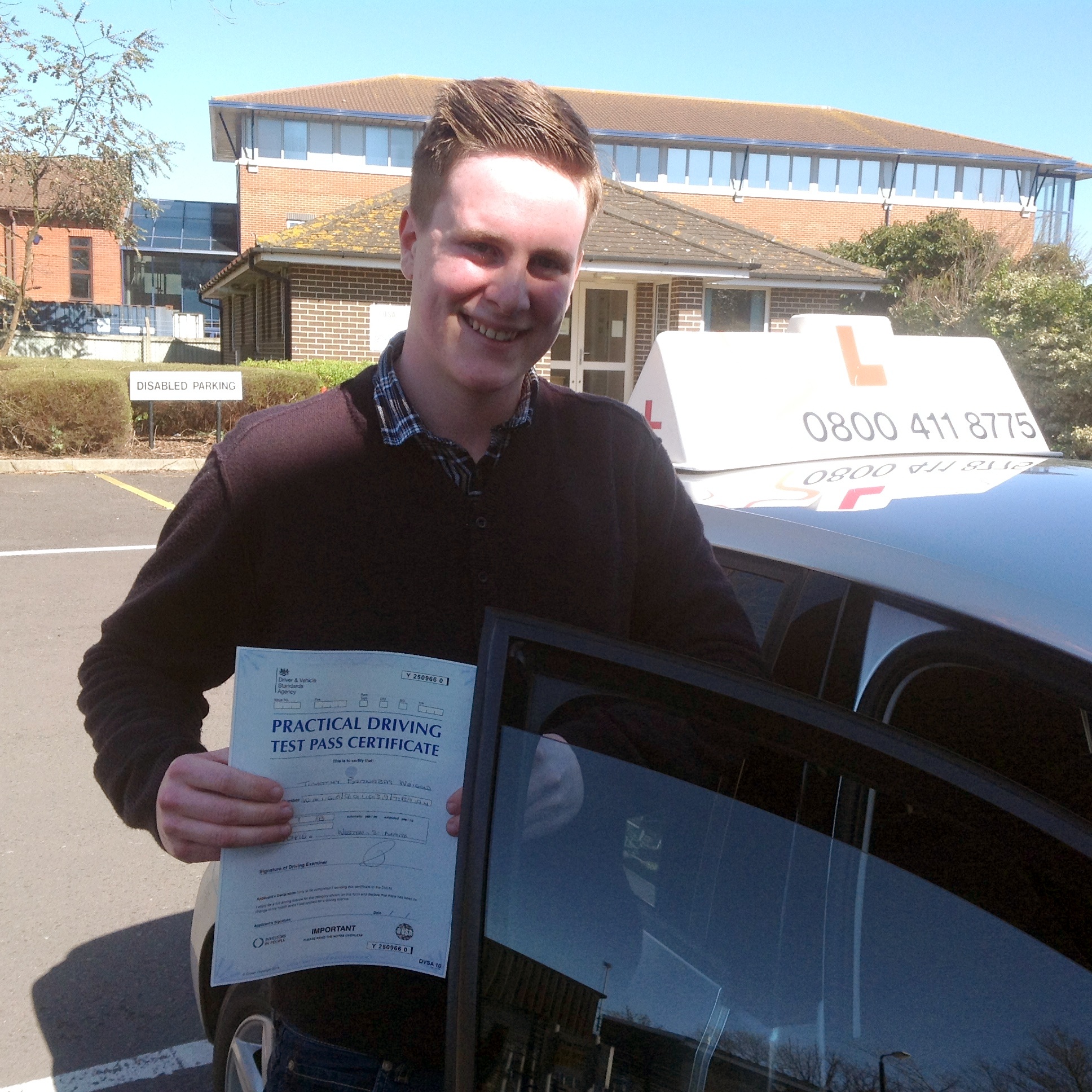 Tim with his Practical Driving Test Pass Certificate outside Weston-super-Mare Driving Test Centre.
