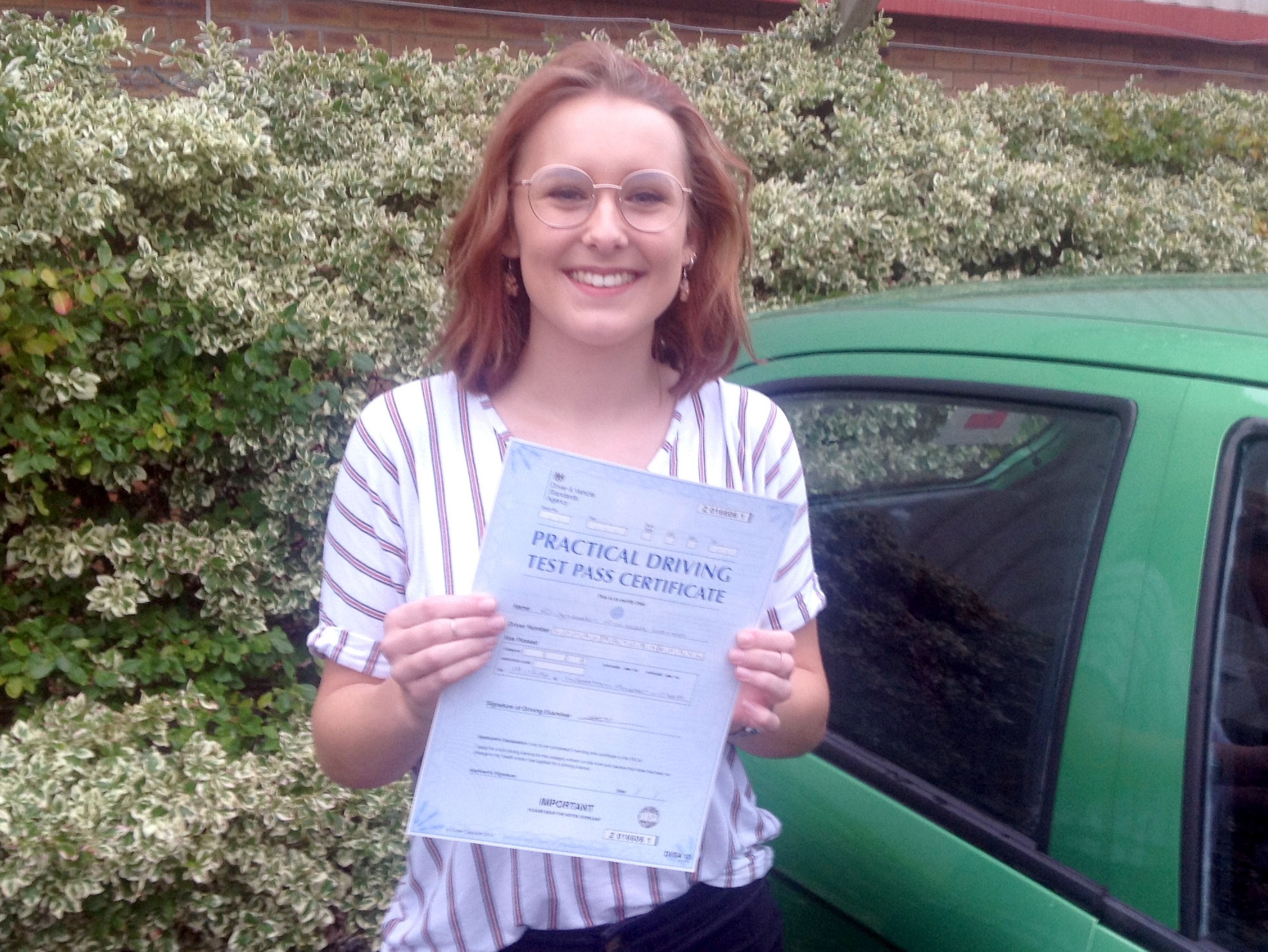 Lizzie with her Practical Driving Test Pass Certificate outside Weston-super-mare Driving Test Centre