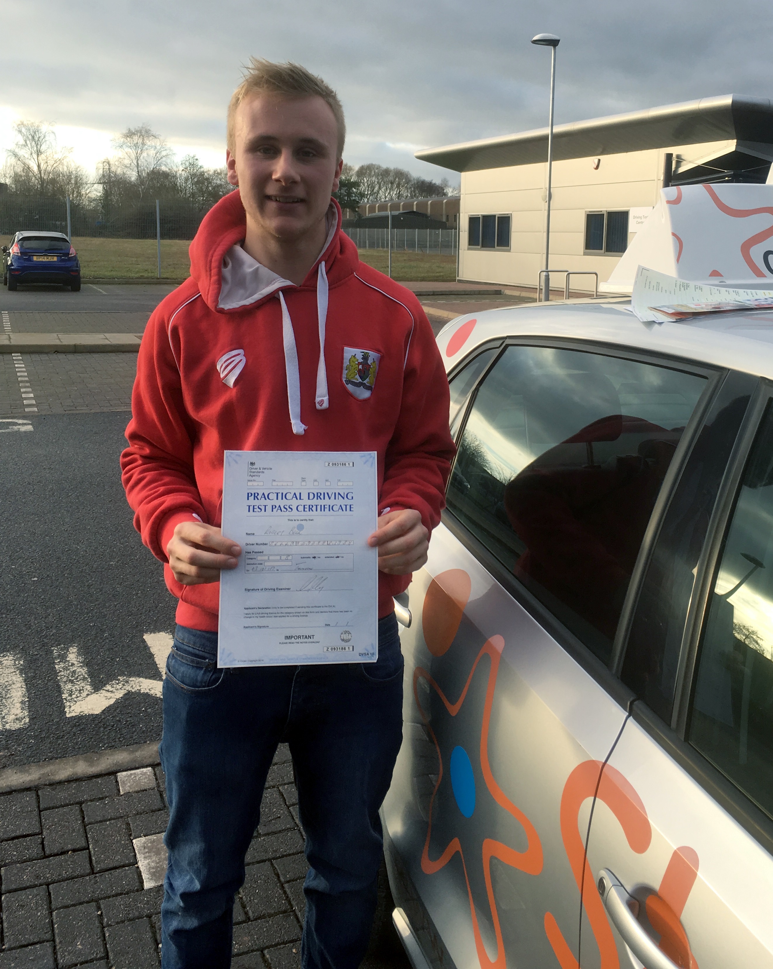 Robbie with his Practical Driving Test Pass Certificate outside Taunton Driving Test Centre
